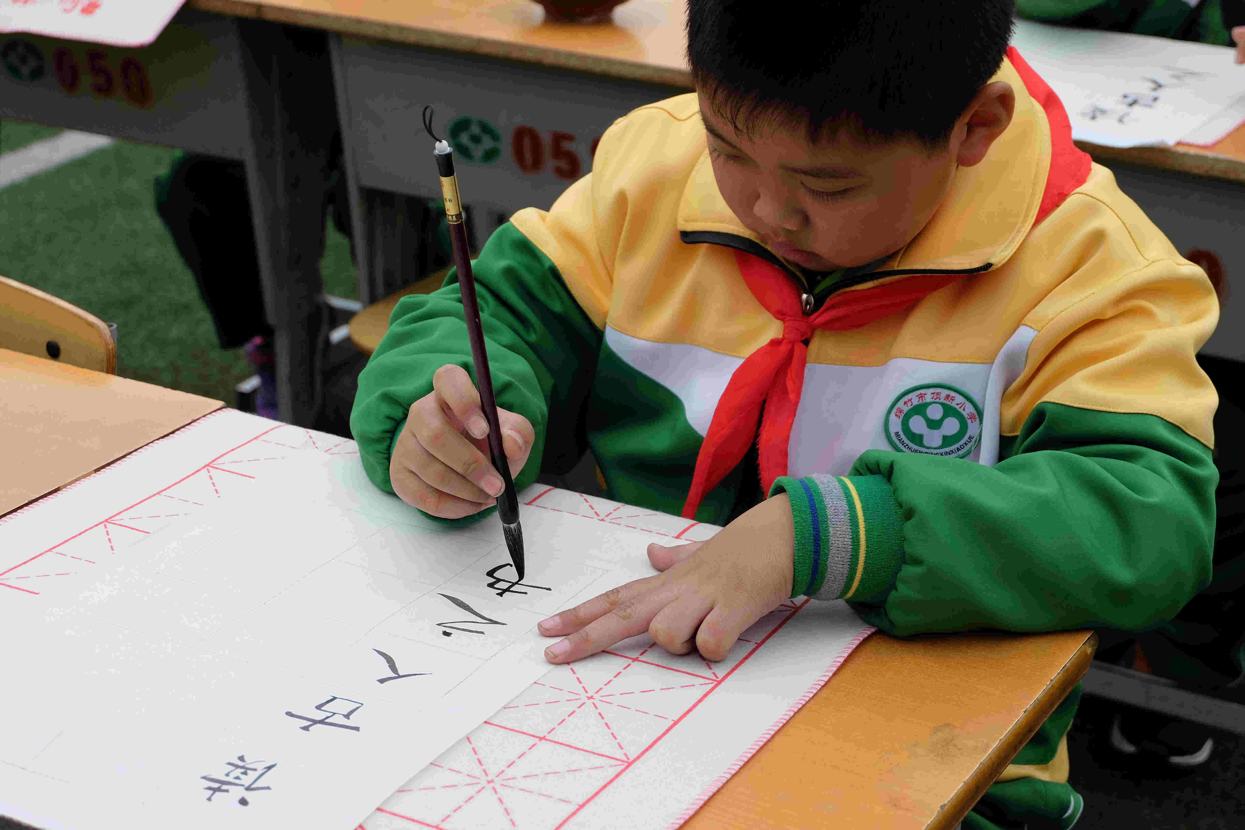 1486968433132892.jpg 五一班罗晨正在书写毛笔.jpg